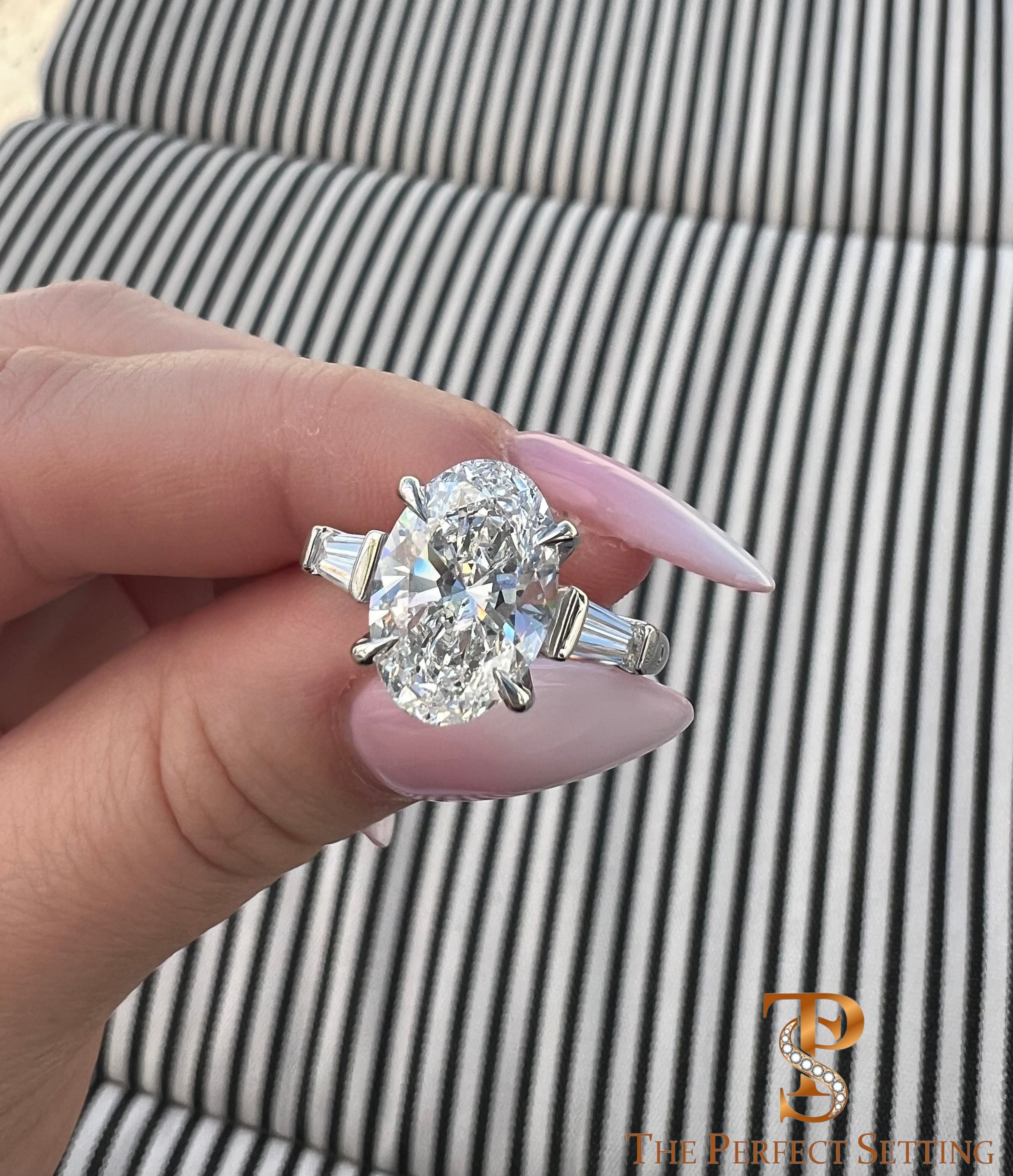 The Perfect Setting, Inc. platinum engagement ring with a 3 carat oval diamond and tapered baguette side stones.