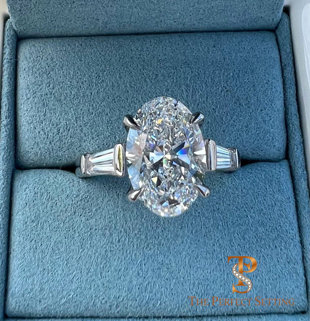 The Perfect Setting, Inc. platinum engagement ring featuring a 3 carat oval diamond with tapered baguette side stones.