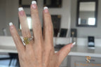 The Perfect Setting, Inc emerald cut vivid yellow diamond engagement ring with baguette side stones on a hand.