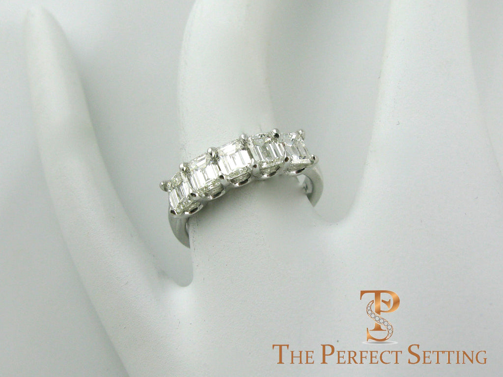 5 stone emerald cut diamond wedding band on finger