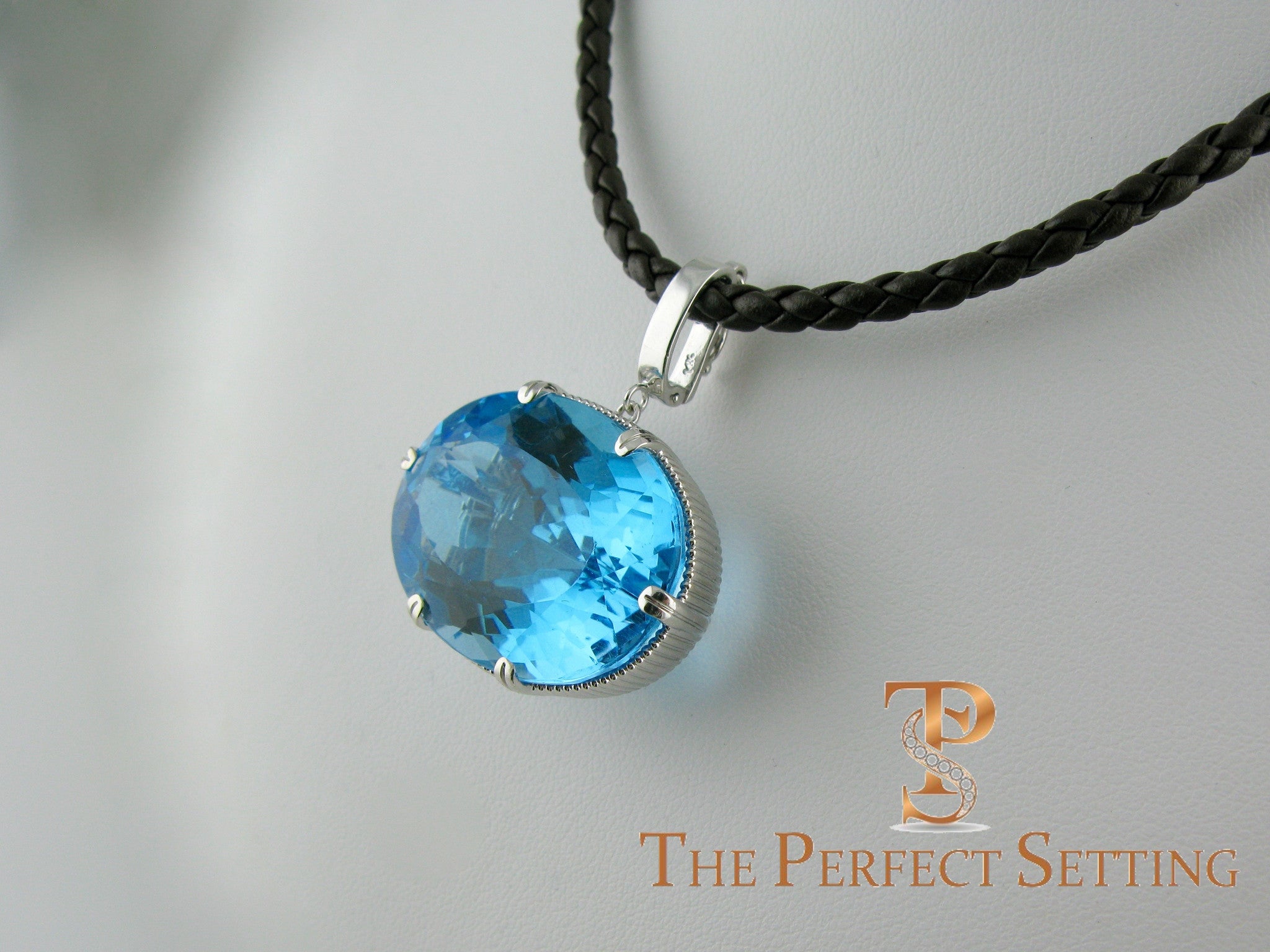 side view of large blue tourmaline on leather cord