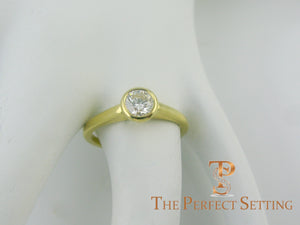 GIA certified round diamond bezel set ring on finger